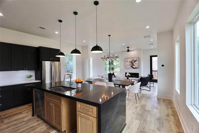 609 E 38th St, Houston, TX 77022 - kitchen with freestanding refrigerator, a sink, dishwashing machine, light wood-style floors, and recessed lighting