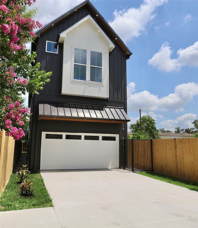 609 E 38th St, Houston, TX 77022 - view of front facade featuring a standing seam roof, board and batten siding, an attached garage, concrete driveway, and a metal roof