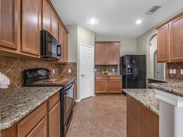 17510 Durham Ridge Ln, Humble, TX 77346 - kitchen with black appliances, backsplash, arched walkways, light stone countertops, and recessed lighting