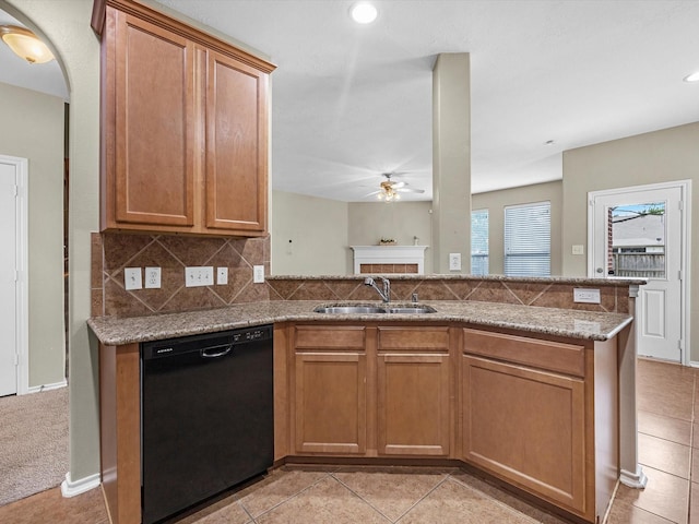 17510 Durham Ridge Ln, Humble, TX 77346 - kitchen with black dishwasher, a sink, ceiling fan, a fireplace, and light stone countertops