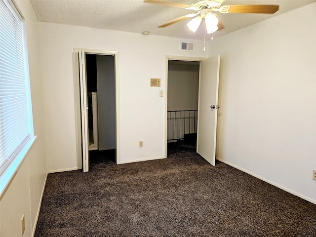 5670 Birchmont Dr Unit C, Houston, TX 77091 - unfurnished bedroom with dark colored carpet, multiple windows, baseboards, and ceiling fan
