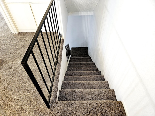 5670 Birchmont Dr Unit C, Houston, TX 77091 - stairway featuring a textured ceiling