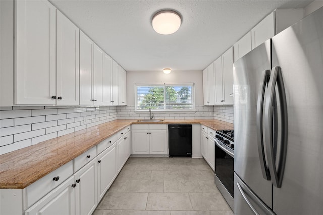127 E Thornton Rd, Houston, TX 77022 - kitchen with appliances with stainless steel finishes, a sink, decorative backsplash, white cabinets, and light tile patterned floors