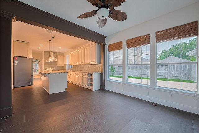 5918 Pendelton Place Dr, Sugar Land, TX 77479 - kitchen featuring freestanding refrigerator, ceiling fan, a center island, baseboards, and light stone countertops