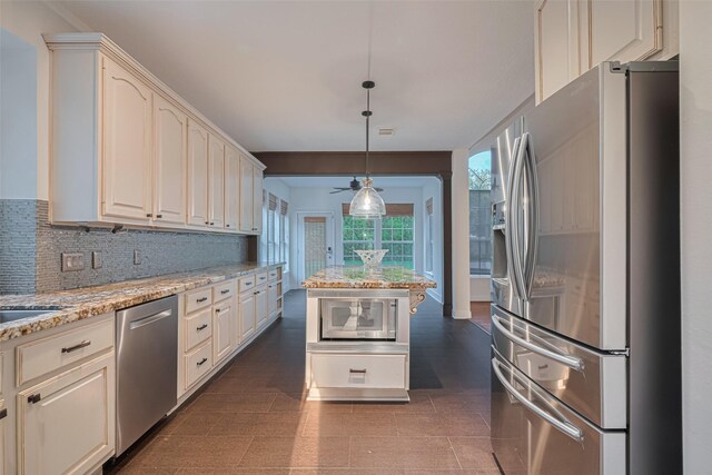 5918 Pendelton Place Dr, Sugar Land, TX 77479 - kitchen with appliances with stainless steel finishes, light stone counters, pendant lighting, decorative backsplash, and ceiling fan
