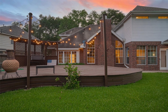5918 Pendelton Place Dr, Sugar Land, TX 77479 - back of property at dusk with brick siding, a lawn, a chimney, and a wooden deck