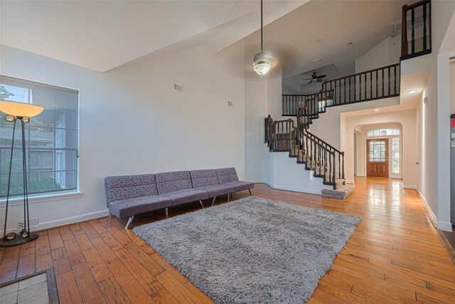 5918 Pendelton Place Dr, Sugar Land, TX 77479 - living area featuring light wood-style floors, stairway, baseboards, arched walkways, and high vaulted ceiling