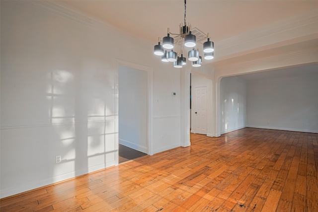 5918 Pendelton Place Dr, Sugar Land, TX 77479 - unfurnished room with ornamental molding, a chandelier, hardwood / wood-style floors, baseboards, and arched walkways