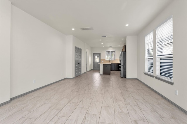 15206 Falco Ln, Magnolia, TX 77354 - unfurnished living room featuring recessed lighting, a sink, and baseboards