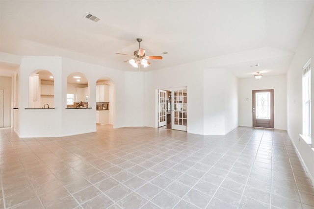 13507 Marblepointe Ln, Cypress, TX 77429 - unfurnished living room featuring light tile patterned floors, ceiling fan, baseboards, and arched walkways