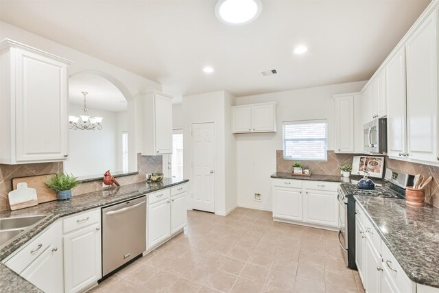 13507 Marblepointe Ln, Cypress, TX 77429 - kitchen featuring stainless steel appliances, tasteful backsplash, a chandelier, white cabinets, and recessed lighting