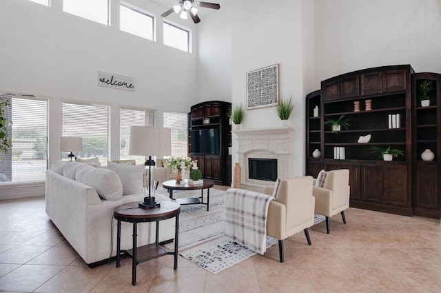11307 Bentgrove Ln, Cypress, TX 77433 - living room featuring a fireplace, a towering ceiling, a ceiling fan, and light tile patterned floors