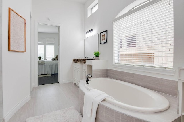 11307 Bentgrove Ln, Cypress, TX 77433 - ensuite bathroom with healthy amount of natural light, vanity, a bath, and baseboards