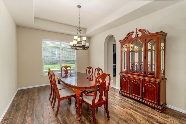 1938 Honey Laurel Dr, Conroe, TX 77304 - dining space featuring arched walkways, a chandelier, a raised ceiling, and dark wood-style flooring