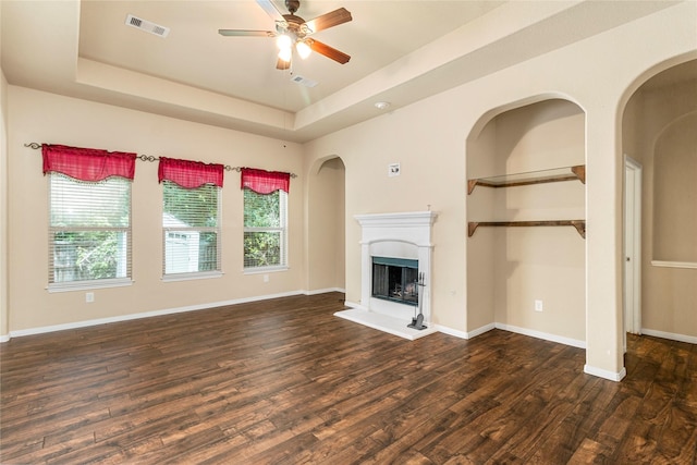 1938 Honey Laurel Dr, Conroe, TX 77304 - unfurnished living room featuring wood finished floors, a tray ceiling, a ceiling fan, and a fireplace with raised hearth