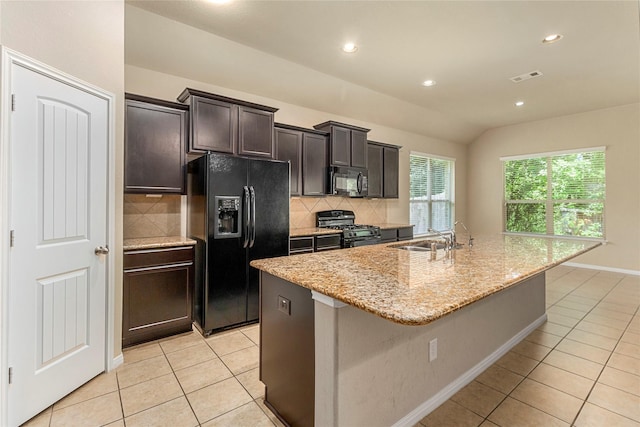 1938 Honey Laurel Dr, Conroe, TX 77304 - kitchen with black appliances, a sink, light tile patterned floors, an island with sink, and backsplash