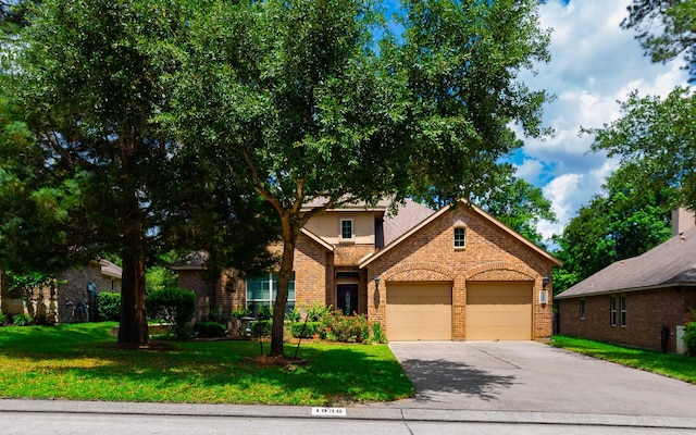 1938 Honey Laurel Dr, Conroe, TX 77304 - view of front of house featuring brick siding, an attached garage, concrete driveway, and a front yard