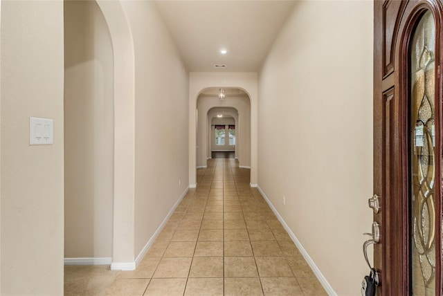 1938 Honey Laurel Dr, Conroe, TX 77304 - hall with arched walkways, light tile patterned flooring, baseboards, and recessed lighting