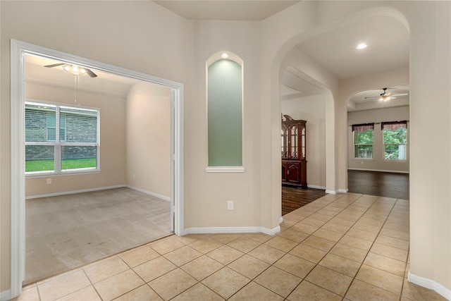 1938 Honey Laurel Dr, Conroe, TX 77304 - spare room featuring a ceiling fan, light tile patterned floors, arched walkways, and baseboards
