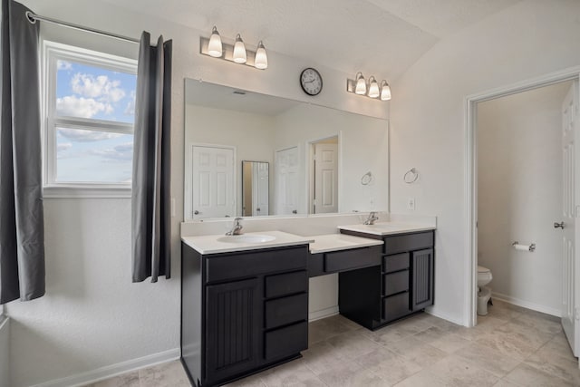 9001 Cimarron River Ln, Magnolia, TX 77354 - bathroom featuring double vanity, toilet, lofted ceiling, tile patterned flooring, and baseboards