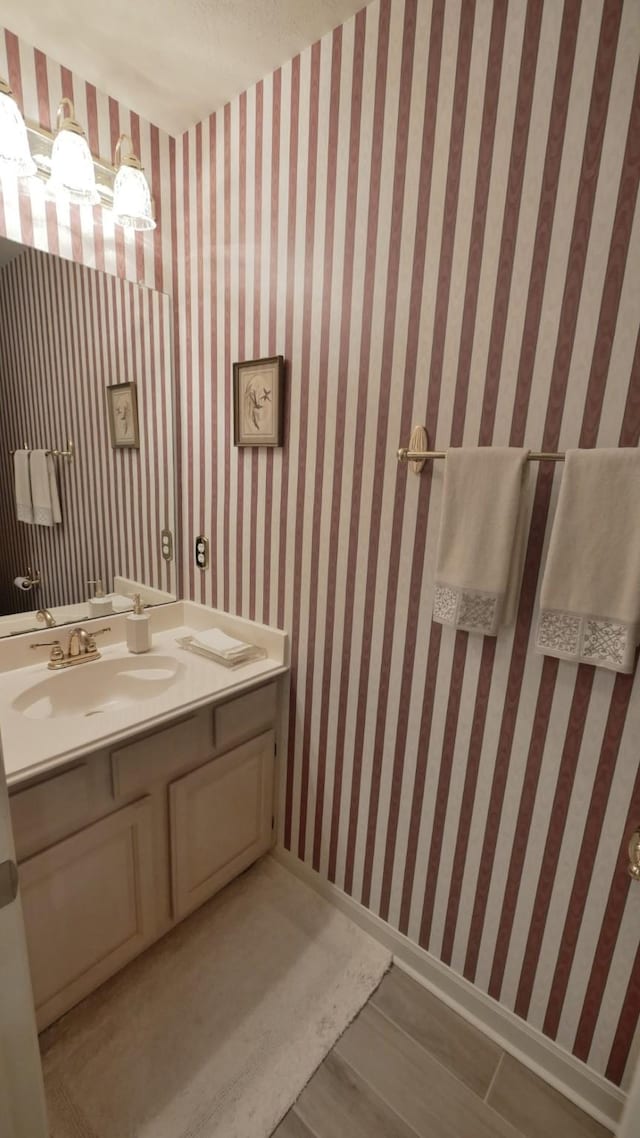 7907 Gulf Isle Ct NE, Houston, TX 77095 - bathroom with vanity, baseboards, and wood finished floors
