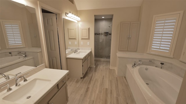 7907 Gulf Isle Ct NE, Houston, TX 77095 - bathroom featuring a garden tub, two vanities, a shower stall, and wood finished floors
