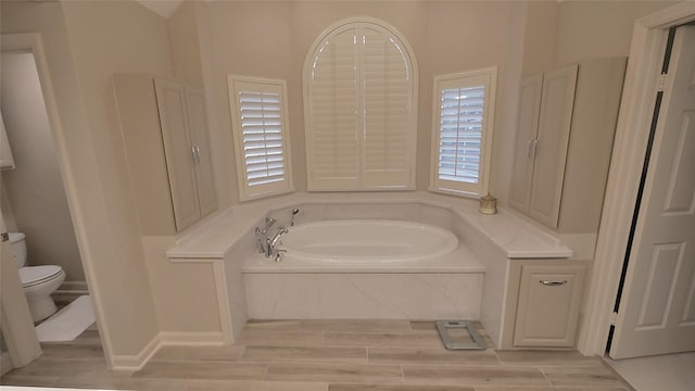 7907 Gulf Isle Ct NE, Houston, TX 77095 - bathroom featuring a bath, wood finished floors, and toilet