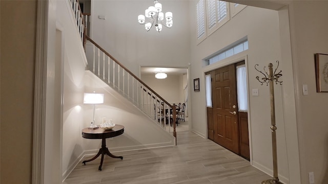 7907 Gulf Isle Ct NE, Houston, TX 77095 - entrance foyer featuring stairs, light wood-style floors, baseboards, a high ceiling, and a chandelier