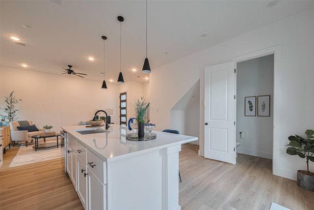 2706 Bostic St, Houston, TX 77093 - kitchen featuring a sink, ceiling fan, light wood-style floors, white cabinetry, and light countertops