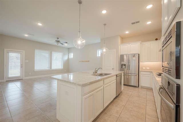 8107 Silverspot Ln, Missouri City, TX 77459 - kitchen with stainless steel appliances, a sink, light tile patterned flooring, light stone counters, and recessed lighting