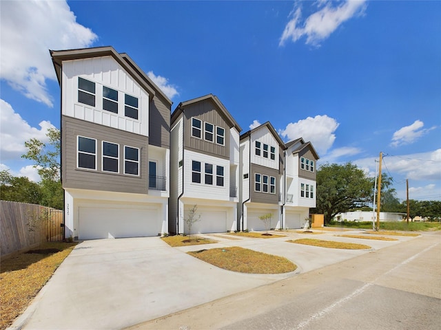 6834 Lozier St, Houston, TX 77021 - view of front facade with board and batten siding, a garage, fence, and driveway