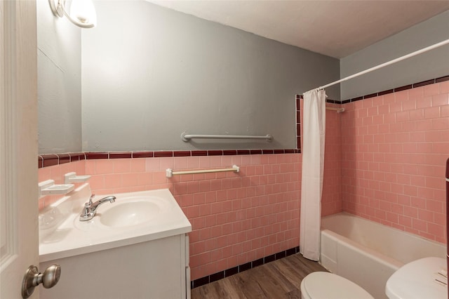 2910 John St, La Marque, TX 77568 - full bathroom featuring toilet, tile walls, wood finished floors, vanity, and wainscoting