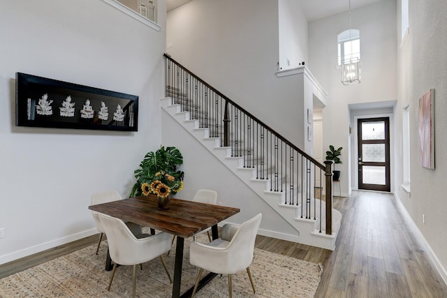 20923 Grand Surprise Ct, Cypress, TX 77433 - dining room featuring wood finished floors, a towering ceiling, healthy amount of natural light, stairs, and baseboards