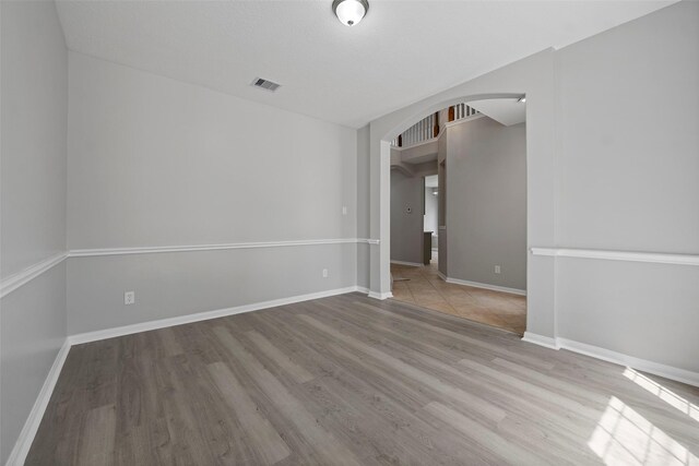 18438 Brenwood Manor Dr, Katy, TX 77449 - spare room featuring arched walkways, wood finished floors, and baseboards