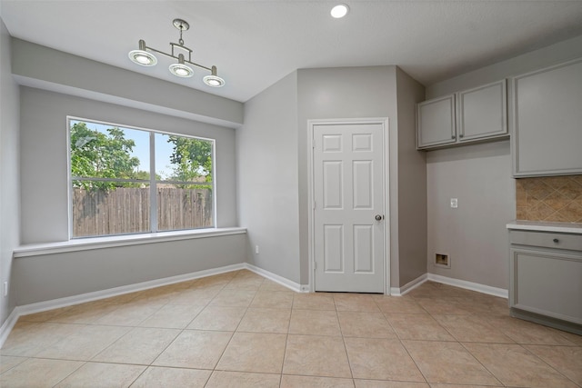 18438 Brenwood Manor Dr, Katy, TX 77449 - unfurnished dining area with light tile patterned flooring and baseboards