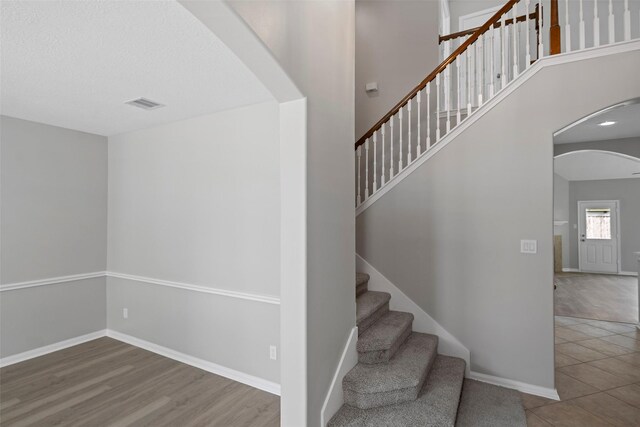 18438 Brenwood Manor Dr, Katy, TX 77449 - stairway with arched walkways, baseboards, and wood finished floors
