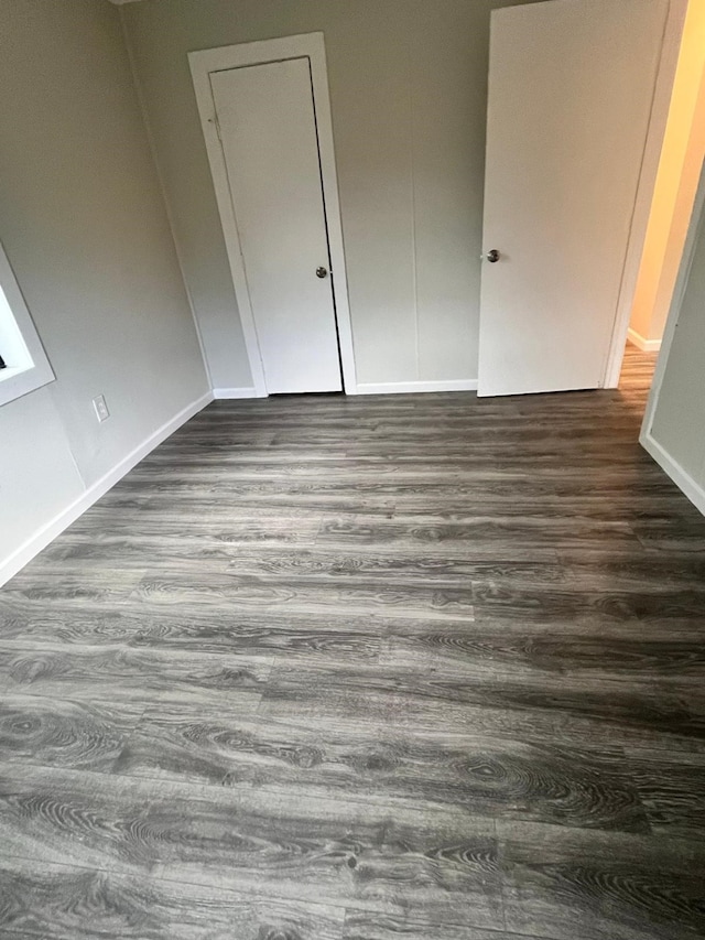 1202 13th St N, Texas City, TX 77590 - unfurnished bedroom featuring dark wood finished floors and baseboards