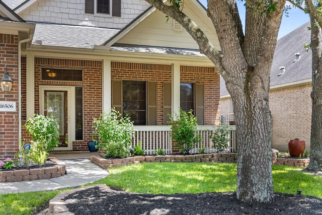16506 Shimmering Lake Dr, Cypress, TX 77433 - doorway to property featuring covered porch, brick siding, and a shingled roof