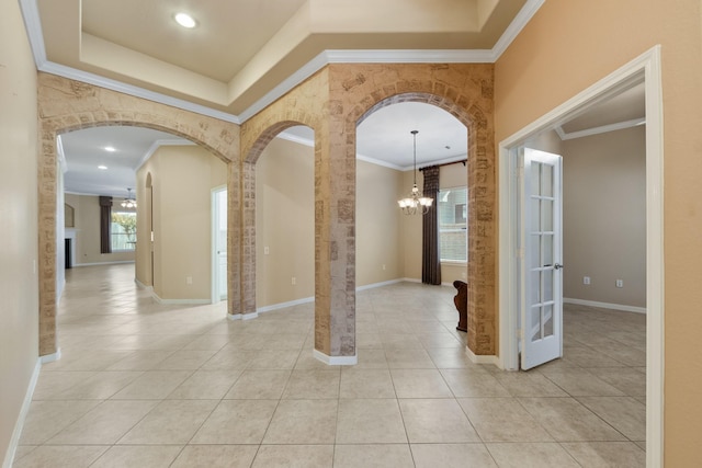 16506 Shimmering Lake Dr, Cypress, TX 77433 - foyer with crown molding, arched walkways, light tile patterned flooring, a chandelier, and baseboards