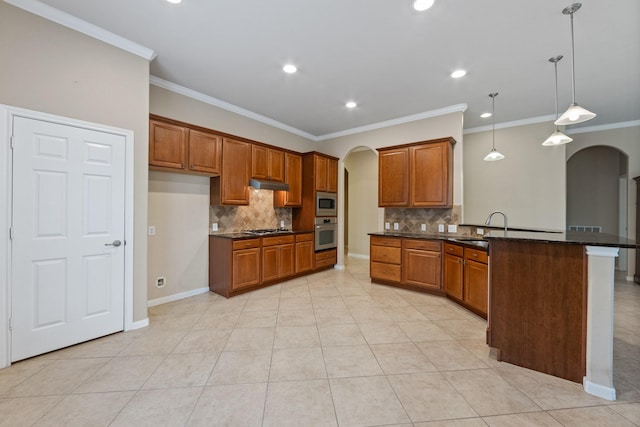 16506 Shimmering Lake Dr, Cypress, TX 77433 - kitchen featuring arched walkways, appliances with stainless steel finishes, a peninsula, brown cabinetry, and tasteful backsplash