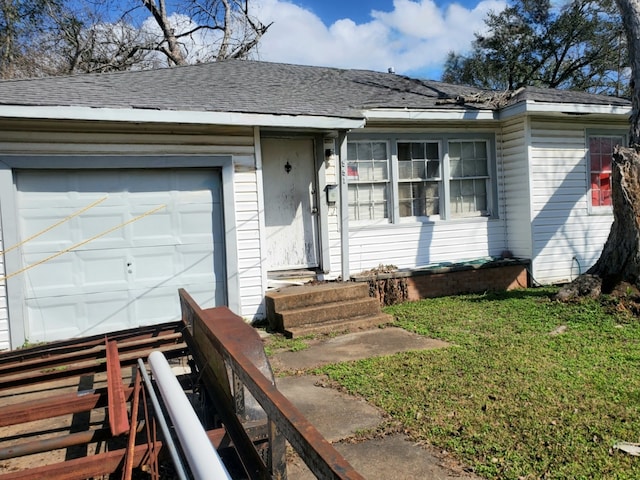 ranch-style home featuring a front lawn, an attached garage, and roof with shingles