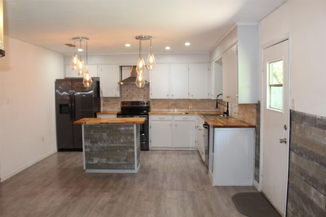 1314 Hooks St, Crockett, TX 75835 - kitchen featuring butcher block counters, range with electric cooktop, black refrigerator with ice dispenser, wall chimney range hood, and white cabinets
