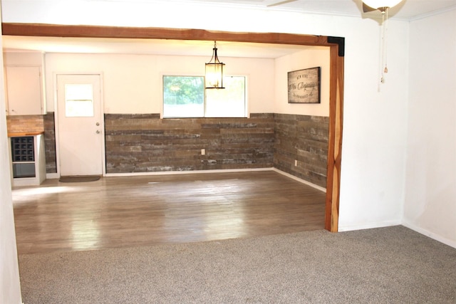 1314 Hooks St, Crockett, TX 75835 - unfurnished dining area featuring carpet flooring, wood finished floors, and a wainscoted wall