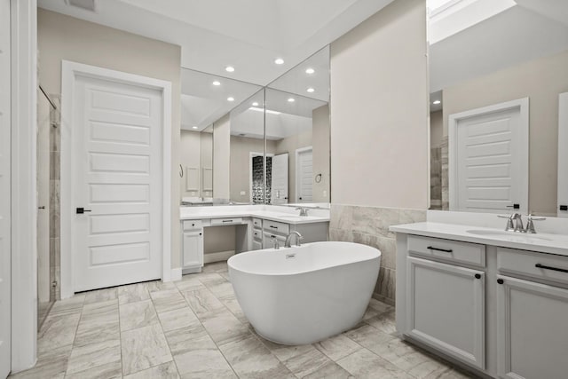 10630 Hazel Hills Dr, Cypress, TX 77433 - bathroom with marble look tiles, recessed lighting, two vanities, a stall shower, and a freestanding tub