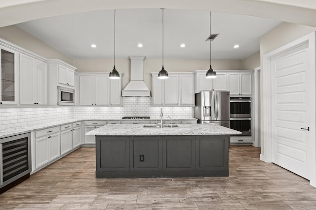 10630 Hazel Hills Dr, Cypress, TX 77433 - kitchen featuring premium range hood, a sink, beverage cooler, stainless steel appliances, and white cabinets