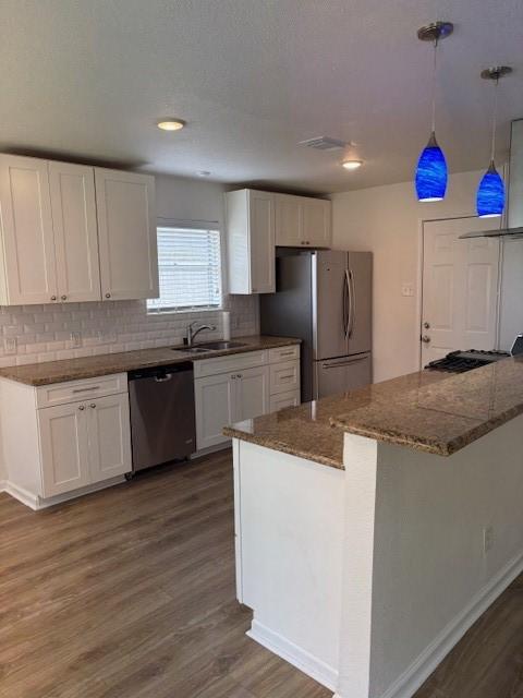 3213 Whitesail Dr, League City, TX 77573 - kitchen featuring stainless steel appliances, dark wood-style floors, white cabinets, tasteful backsplash, and recessed lighting