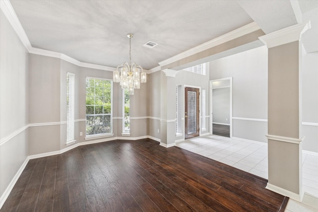 unfurnished room with a chandelier, hardwood / wood-style flooring, ornamental molding, and baseboards
