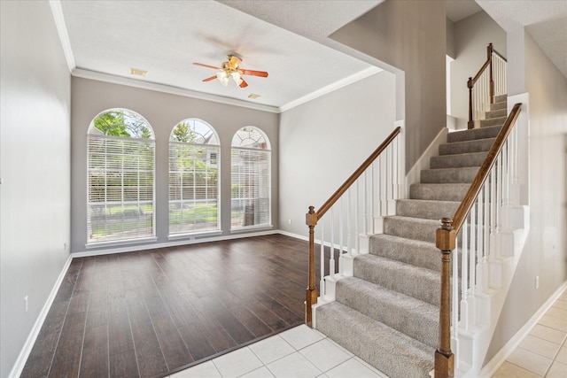 entrance foyer featuring a ceiling fan, plenty of natural light, crown molding, and baseboards