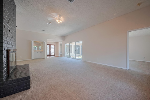 unfurnished living room with a brick fireplace, carpet floors, a ceiling fan, a textured ceiling, and baseboards
