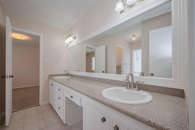 full bath with tile patterned flooring, double vanity, and baseboards
